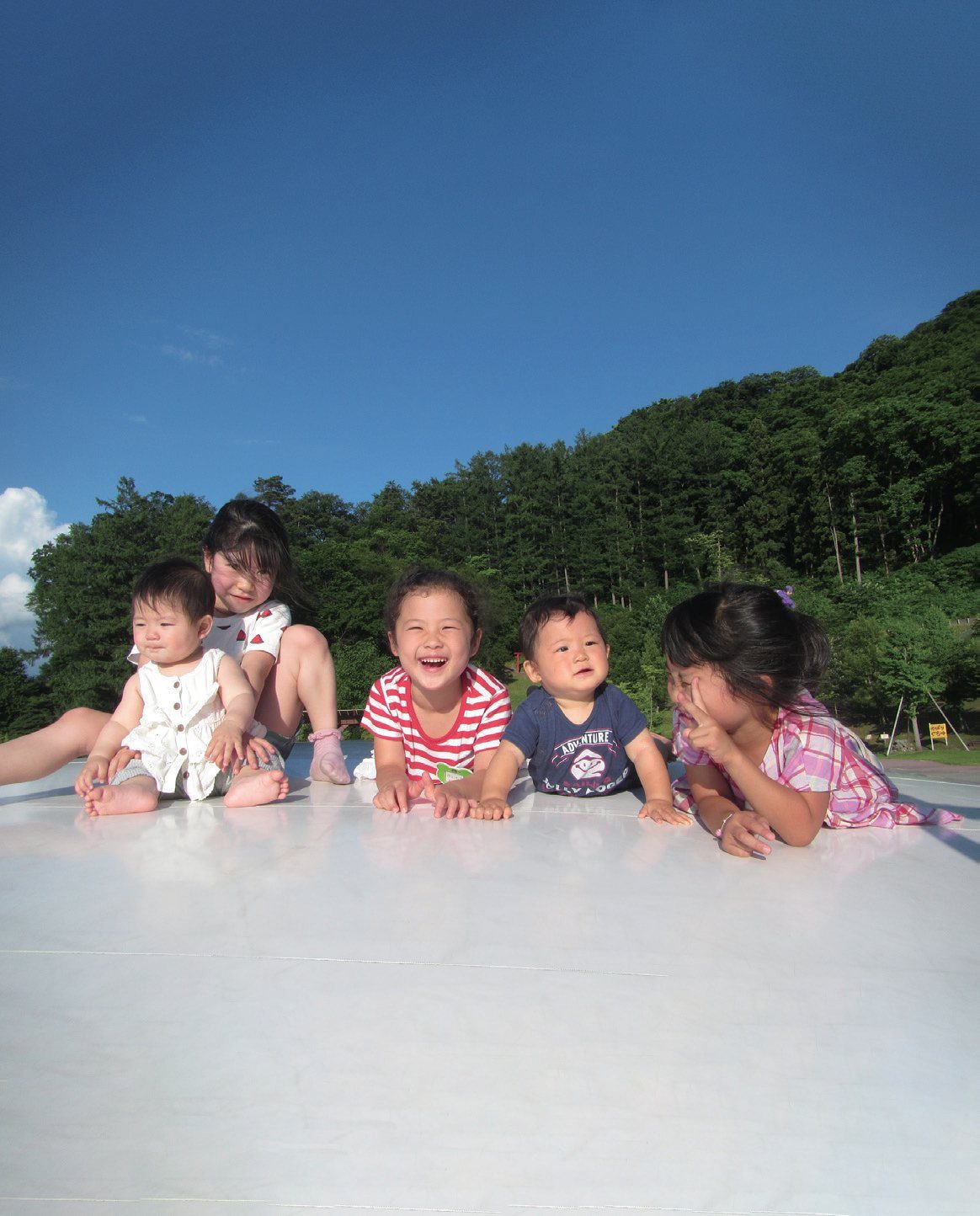 広場で寝ころぶ子どもたち
