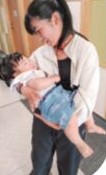 赤ちゃんを抱っこする子ども