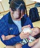 赤ちゃんにミルクをあげる中高生